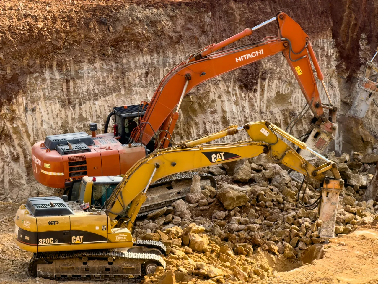 Duas escavadeiras escavando um canteiro de obras